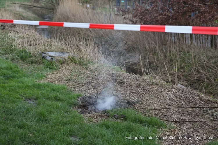 Rook komt uit gras omhoog naast Pannenkoeken paviljoen Cruquius